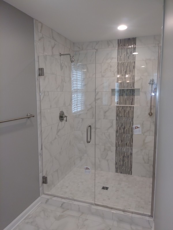 bathroom remodel with white marble tile and glass door shower
